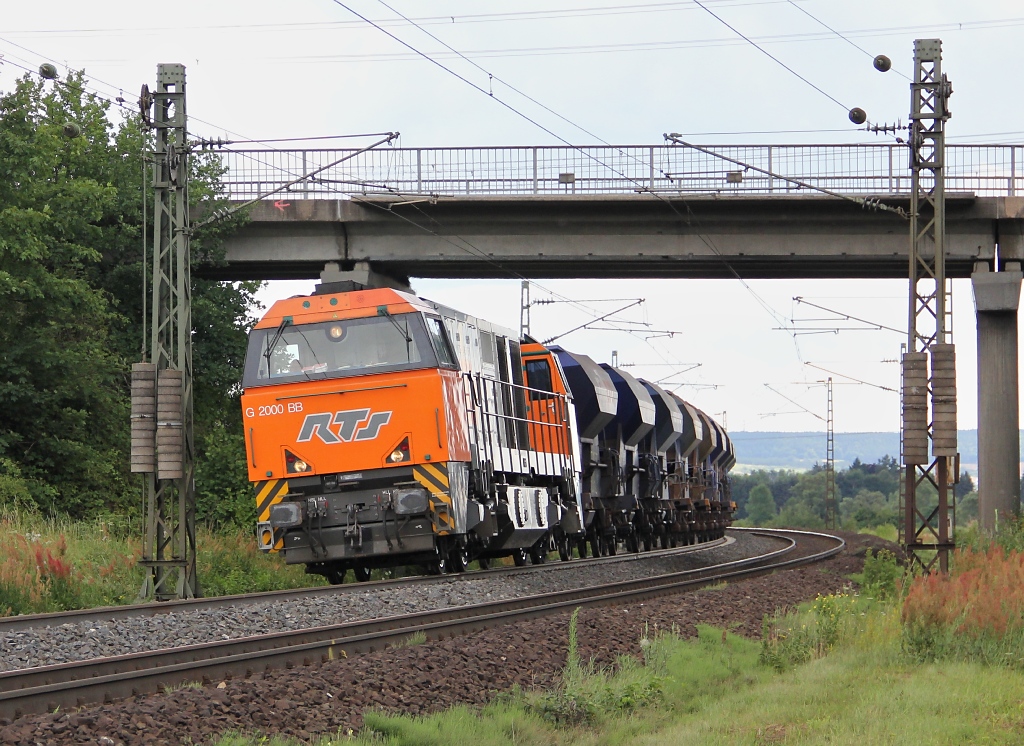 Positionswechsel in die Nhe von Harrbach. Kaum angekommen,
kam auch schon (1)272 205 mit RailPro-Schotterwagen in Richtung Norden um die Ecke.
Aufgenommen am 10.07.2012.