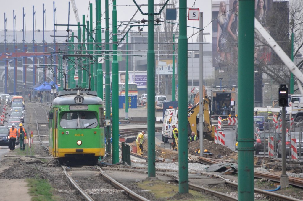 POZNAŃ (Województwo wielkopolskie/Großpolen), 29.04.2013, Wagen 654 als Tramlinie 10 nach Dębiec bei der Ausfahrt aus der Haltestelle Dworzec PKS (im Hintergrund sind die umfangreichen Arbeiten am und um den Hauptbahnhof zu erkennen)