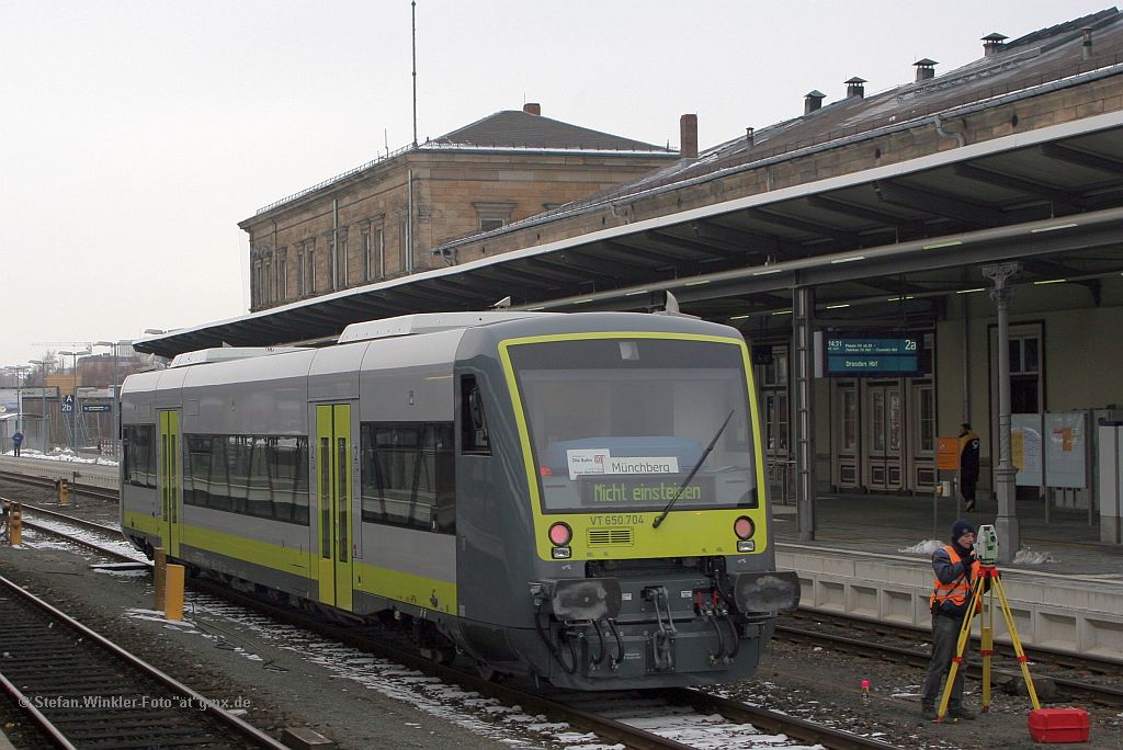 Probebetrieb mit dem neuen Agilis VT 650 704 in Hof Hbf am 15.02.2011: Der VT kommt von der Tankstelle und fhrt auf dem Lokverkehrsgleis zum Abstellplatz wo er bis zum frhen Abend stehen wird. Abends geht es wieder auf die Strecke. Rechts sind Vermesser am Werke...