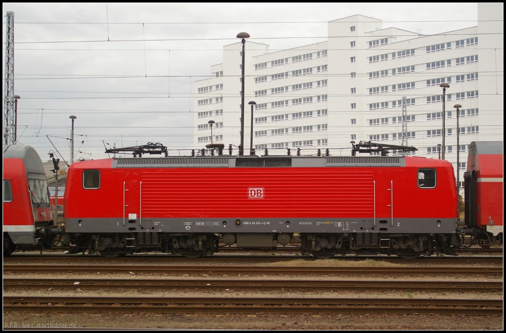 Profilbild mit Warnaufkleber:  Gefhrliche Rckspannung durch stationre elektrische Energieversorgungstation (Zugsammelschiene wird eingespeist) . So stand 114 033-4 zwischen Doppelstockwagen am 10.11.2012 in Berlin-Lichtenberg