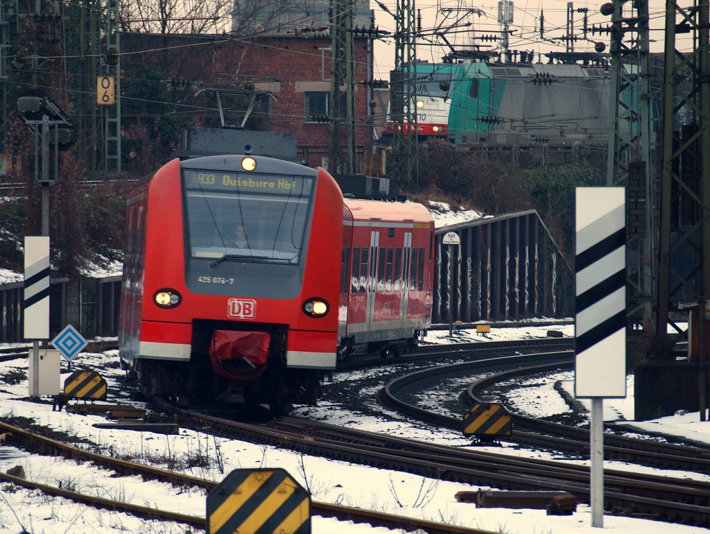 Quitschi 425 076-7 legt sich als RB33 am 03.02.2010 bei der Einfahrt in Aachen West in die Kurve. Im Hintergrund steht 186 202 mit einem gemischten Gterzug vor dem letzten Signal auf der Rampe vom Gemmenicher Tunnel.