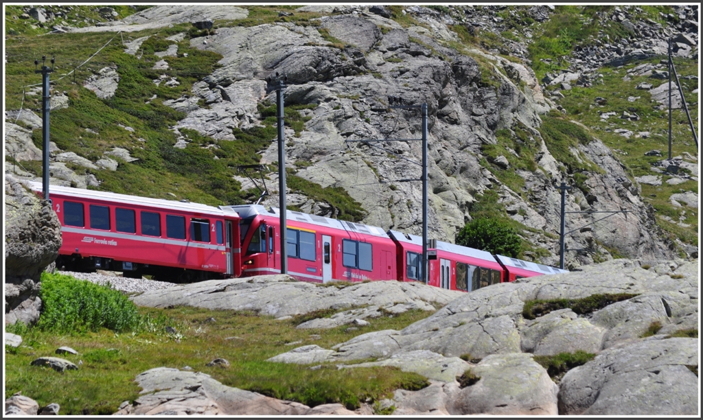 R1629 mit ABe 8/12 3514 zwngt sich zwischen Felsen hindurch entlang des Lago Bianco. (11.08.2012)