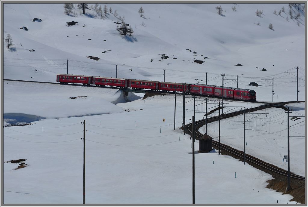 R1644 mit einem Allegra ist auf Talfahrt auf der Alp Bondo. (18.04.2013)