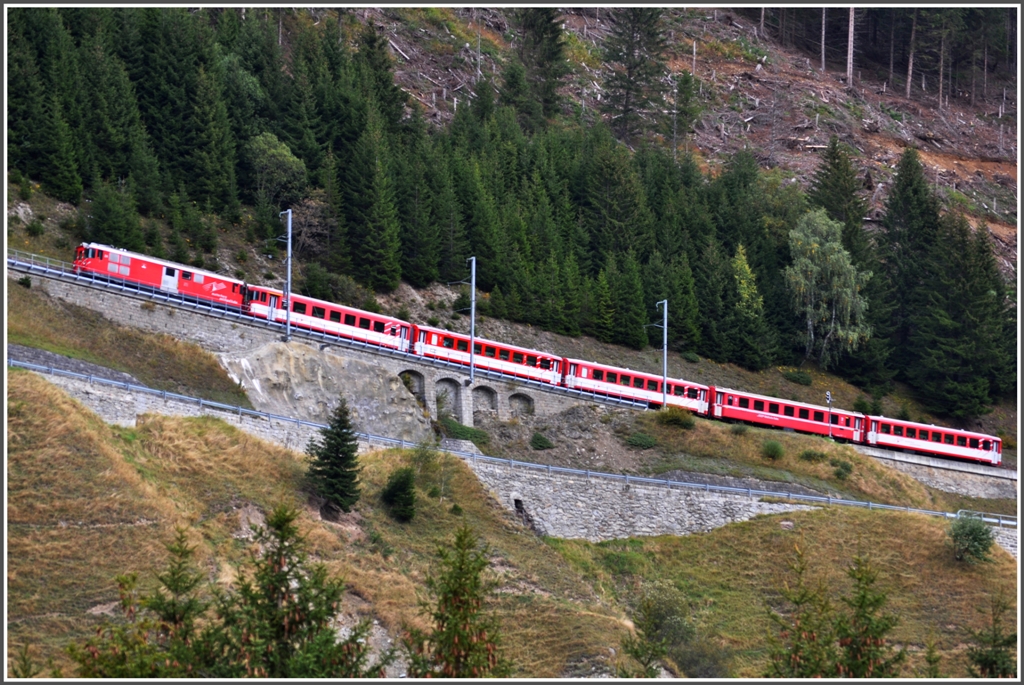 R822 im Zahnstangenabschnitt bei Selva. Der Zug wird von Deh 4/4 24 gezogen. Ich vermute mal weil er zu lang ist und an vierter Stelle ein RhB Wagen mitluft. (25.09.2012)