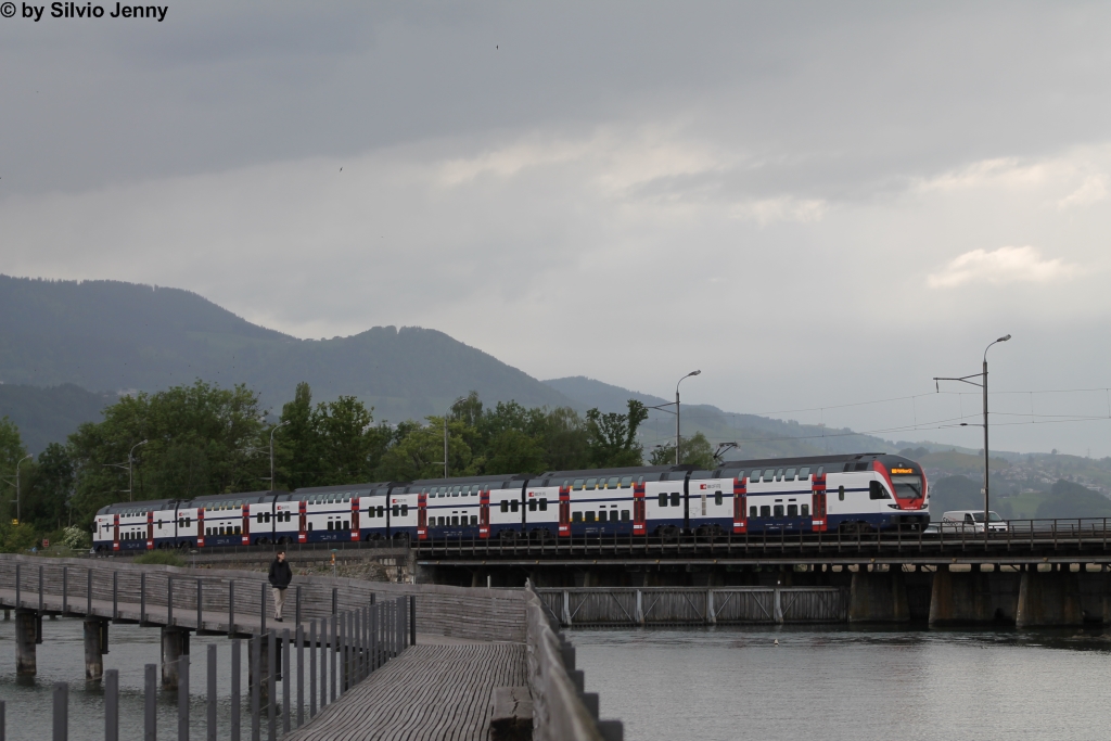 RABe 511 007 am 20.5.2013 kurz vor der Haltestelle Hurden auf dem Rapperswiler Seedam, whrend ber dem Etzel ein heftiger Regenguss aufzog. Im Vordergrund der Holzsteg, erbaut 2001, von dem es mglich ist, diverse Fotos auf dem Seedam zu schiessen.