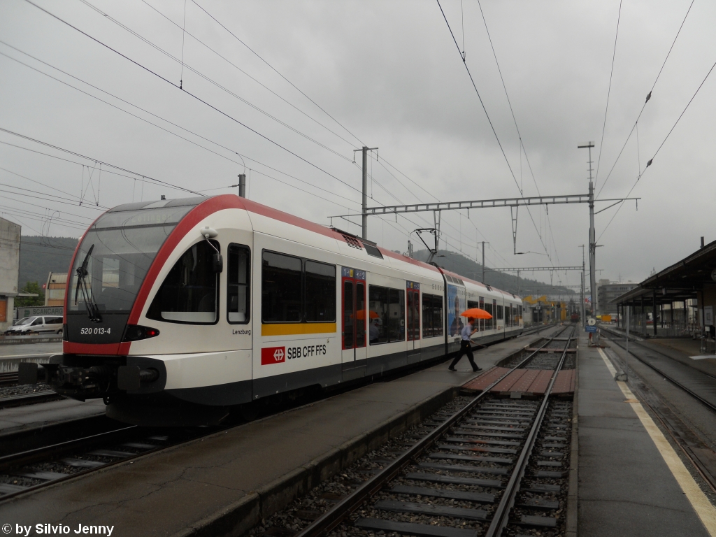 RABe 520 013-4 ''Lenzburg'' verlsst am 2.8.2010 Suhr, nachdem der FDL (im orangen Schirm) den Zug mit der Kelle abgefertigt hat.