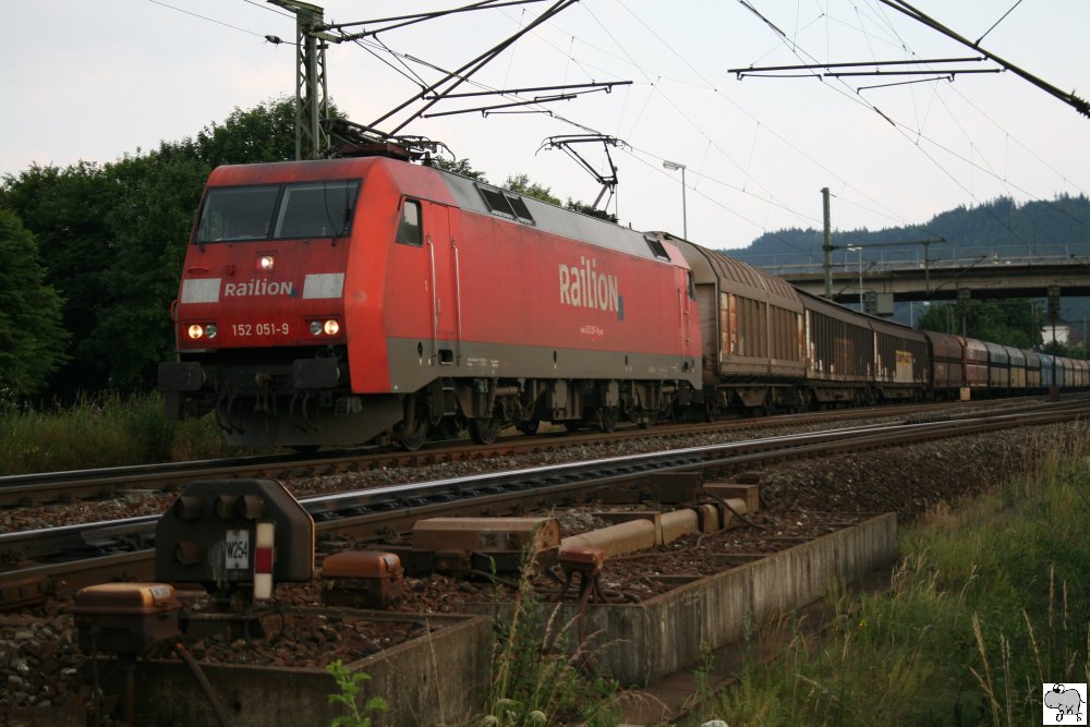 Railion-Lok 152 051-9 verlsst mit einen gemischten Gterzug am 30. Juni 2010 den Bahnhof Pressig-Rothenkirchen. Auf den Gegengleis zeigt bereits das Gleissperrsignal Einfahrt frei fr einen abendlichen Nahverkehrszug.