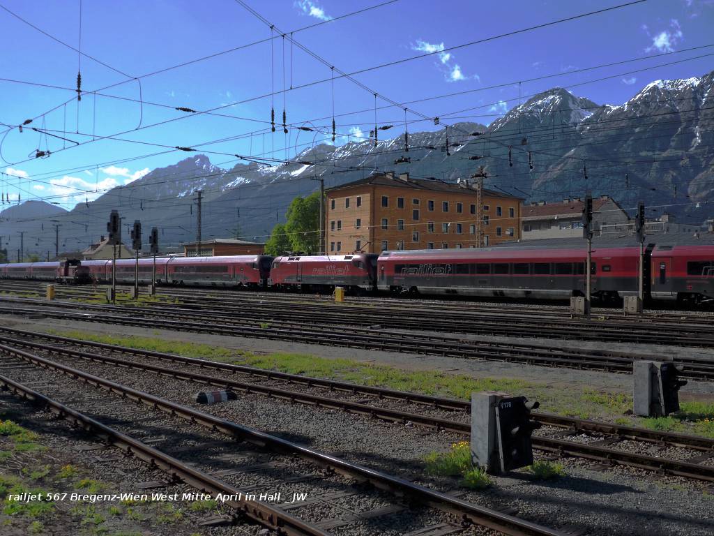 railjet 567 Bregenz - Wien West durchmit eilenden Schrittes Hall. Im Hintergrund die Nordkette vom Hechenberg bis zum Kamm, der das Halltal sdlich begrenzt, davor noch die Rumerspitze. Mitten im Gleisfeld des Haller Bahnhofs eine 2068, die im Rahmen des Fortgangs der Ereignisse bzw. im Gefolge desjenigen des hier dargestellten flchtigen Gastes im Rangieren fortfahren wird, dieses gemeinsam mit ihrer Schwester (siehe folgende Bilder). Mitte April 2011 kHds
