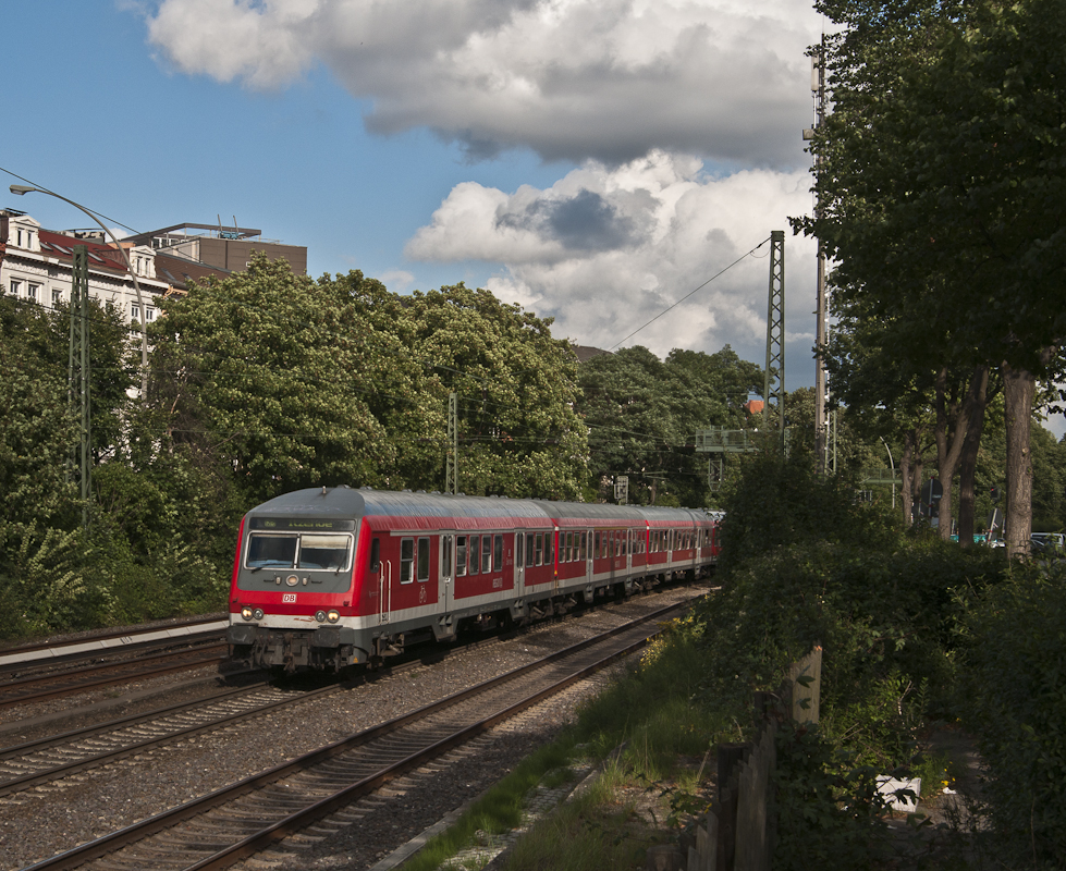 RB 21126 (Hamburg Hbf - Itzehoe) am 25. August 2010 mit Schublok 143 276-4 bei Hamburg Dammtor.