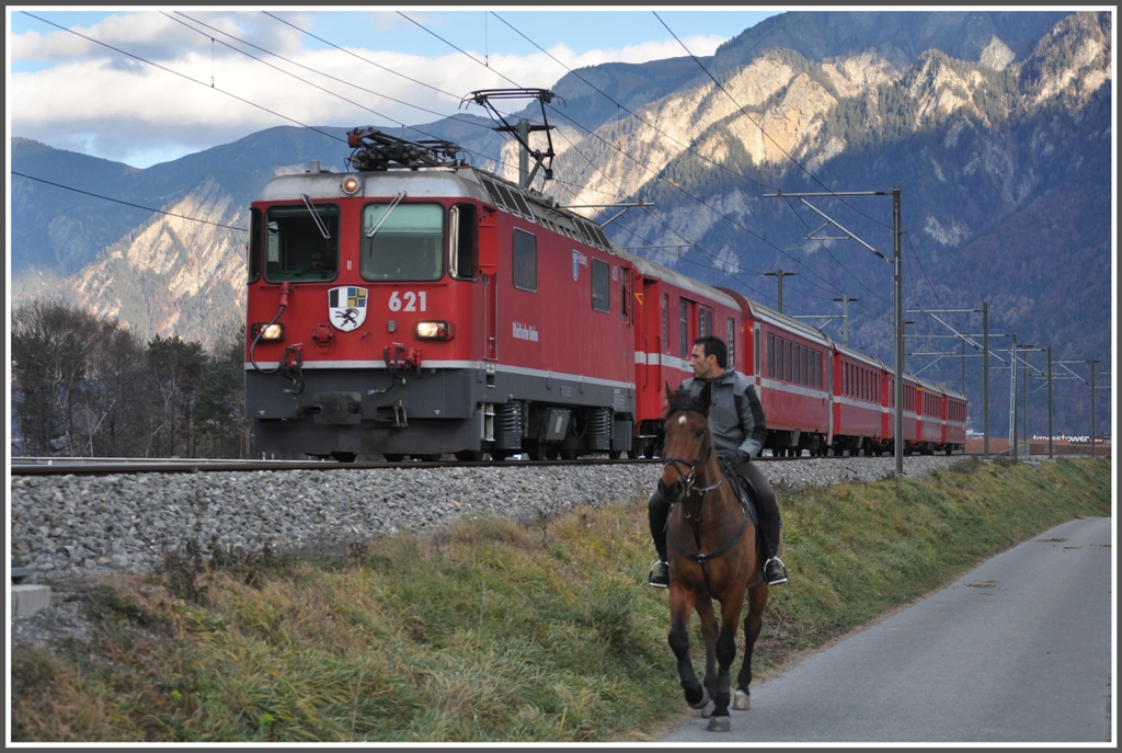 RE 1240 mit Ge 4/4 II 621  Felsberg  berholt bei Felsberg einen Reiter. Das Pferd scheint gewhnt zu sein und lsst sich durch den 80km schnellen Zug nicht aus der Ruhe bringen. (02.12.2011)