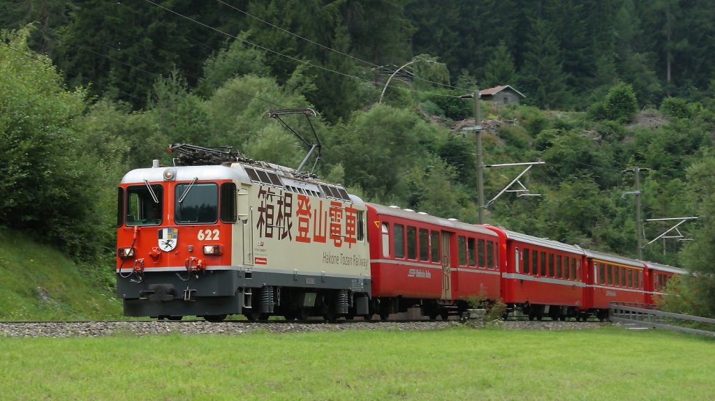 RE 1241 mit Ge 4/4 II 622  Arosa  und Werbung fr die japanische Partnerbahn  Hakone Tozan Railway  bei der Carrerabach-Brcke kurz nach Valendas-Sagogn am 11.08.2010.