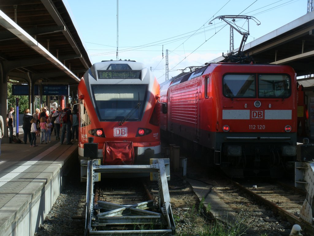RE 13030 links aus Binz und 112 120 mit dem Anschluzug nach Neustrelitz,am 14.August 2013,in Stralsund.