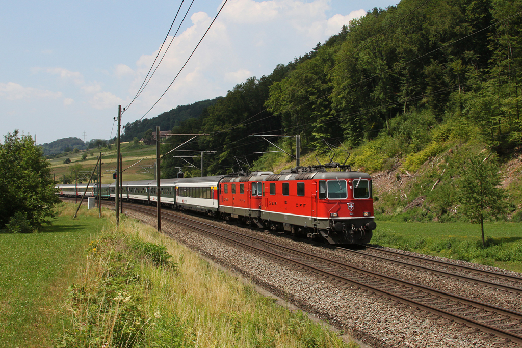 Re 4/4 11135 und eine Schwesterlok mit einem IR (?) am 28.06.2011 bei Tecknau.