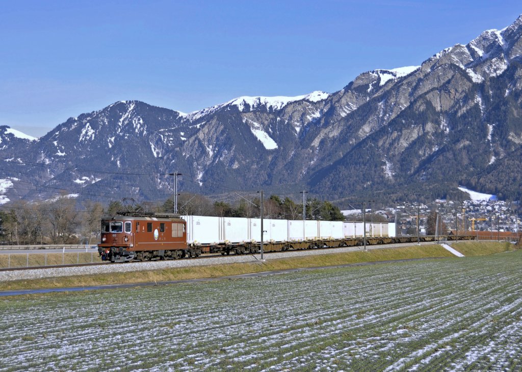 Re 4/4 der BLS alias Re 425 165 getauft auf den Namen``Moutier``ist mit einem Gterzug auf der Fahrt nach Felsberg.Der ´Zug benutzt das dortige Drei-Schienengleis.Bild entstand am 30.1.2013