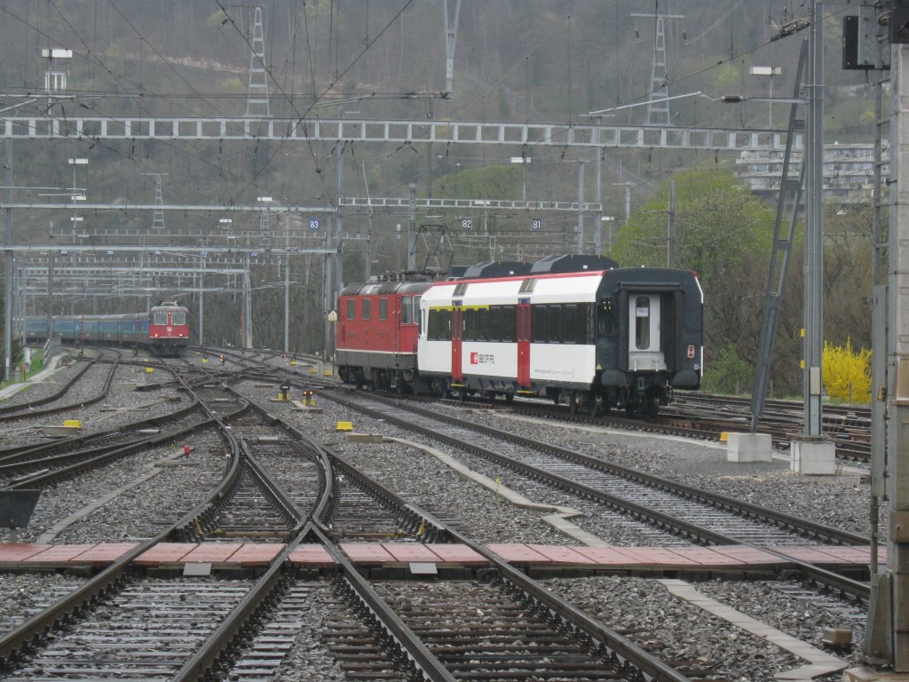 Re 4/4 II 11121 zieht einen neuen Domino ABt von Olten Richtung Yverdon durch den Bahnhof Biel. Links steht ein EW I/II Pendel, mit Re 4/4 II 11125, welcher anschliessend nach Konstanz fhrt, 31.03.2011.