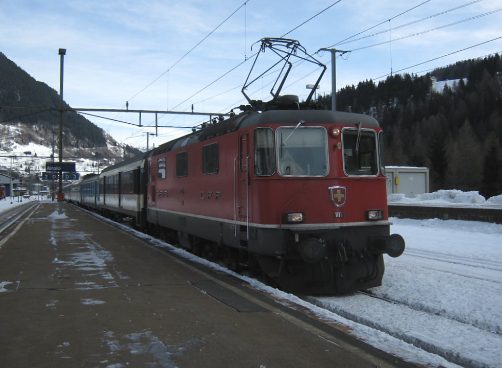 Re 4/4 II 11126 mit IR 2178 in Airolo. An zweiter Stelle ist noch ein A(NL) EW I eingereiht, 27.12.2010.
