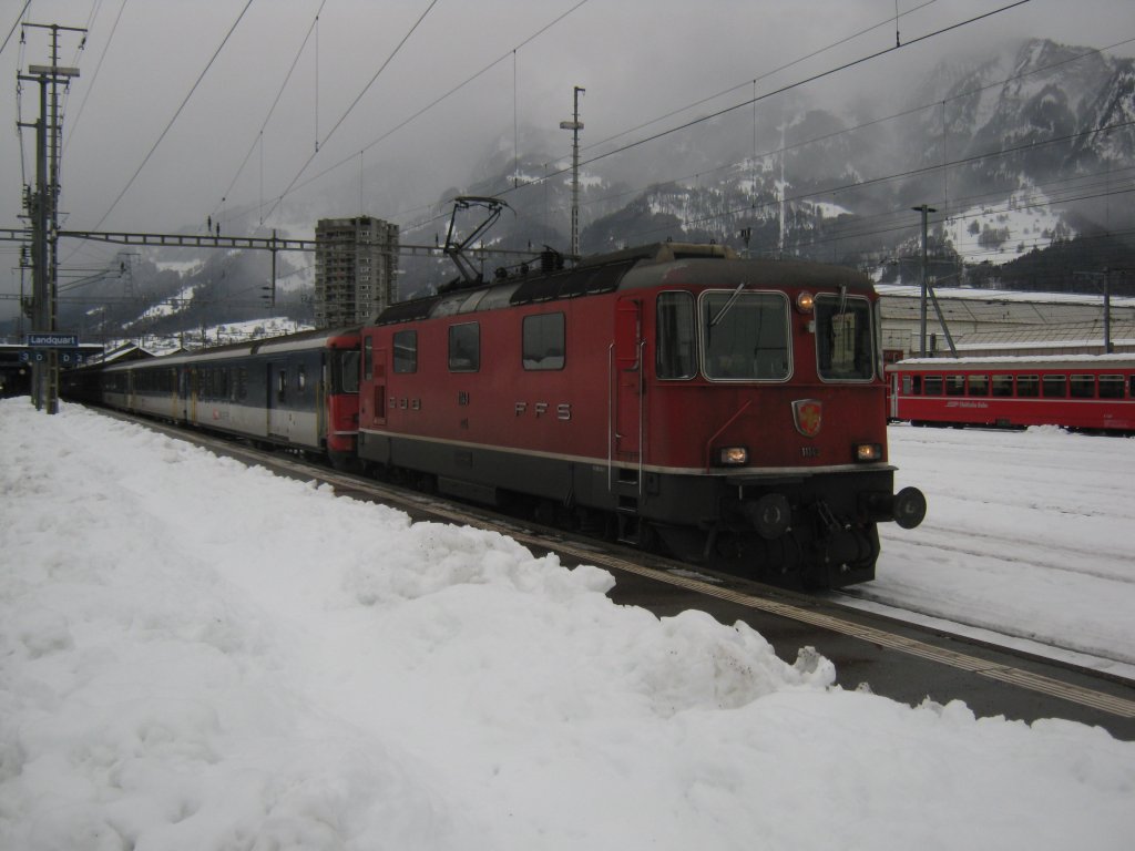 Re 4/4 II 11143 mit IC 10761 in Landquart. Hinter der Lok ist eine Regionalzugkomp, BDt EWII, B EWI, AB EWI angehngt, anschliessend 1 Bpm51, 1Bp, 1Bpm 61 und ein A EWIV. Die Regionalzugwagen (immer BDt, B und AB) werden jeweils Freitags mit dem IC 10788 nach Zrich berfhrt, wo sie ber Nacht bleiben. Am Samstagvormittag gehen sie dann mit dem IC 10761 zurck nach Chur. Unter der Woche fahren sie dann 1 Umlauf pro Tag, 24.12.2011.