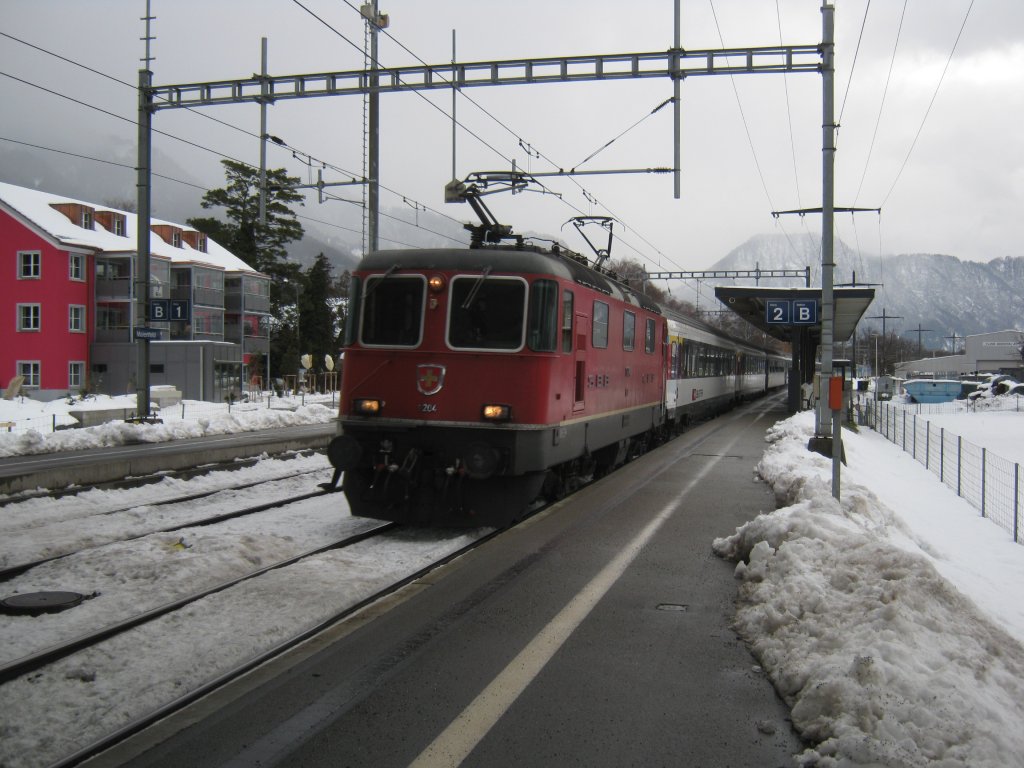 Re 4/4 II 11204 mit Leermaterialzug von Chur-Zrich in Maienfeld. Diese Komp. verkehrte als Entlastugszug 10565 Zrich-Chur, nun fhrt sie leer zurck nach Zrich. Der vordere Bgel wurde durch den Fahrtwind gehoben, 24.12.2011.