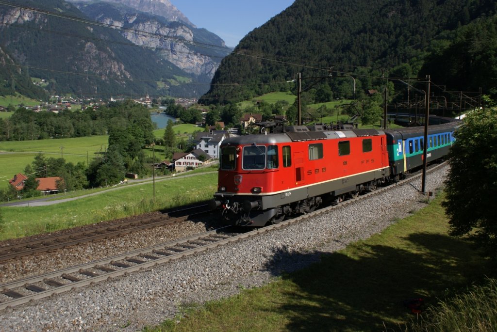 Re 4/4 II 11218 zieht am 26.6.10 den IR 2263 die ersten Rampen des Gotthard bei Erstfeld hinauf.