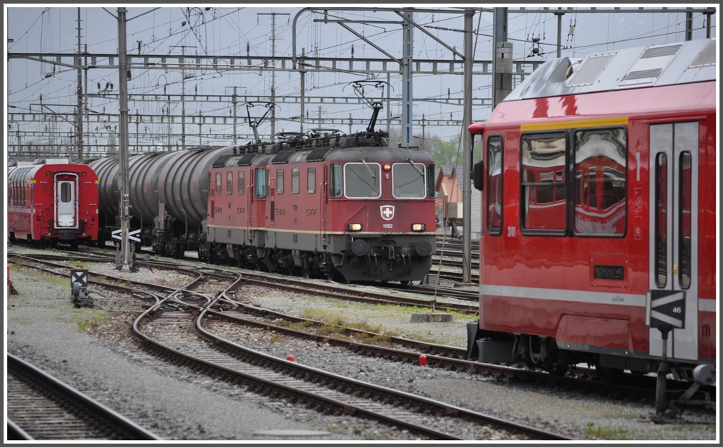 Re 4/4 II 11242 und eine Schwesterlok haben einen schweren Oelzug nach Landquart gebracht. Daneben steht der erste vierteilige Allegra 3101. (30.04.2012)