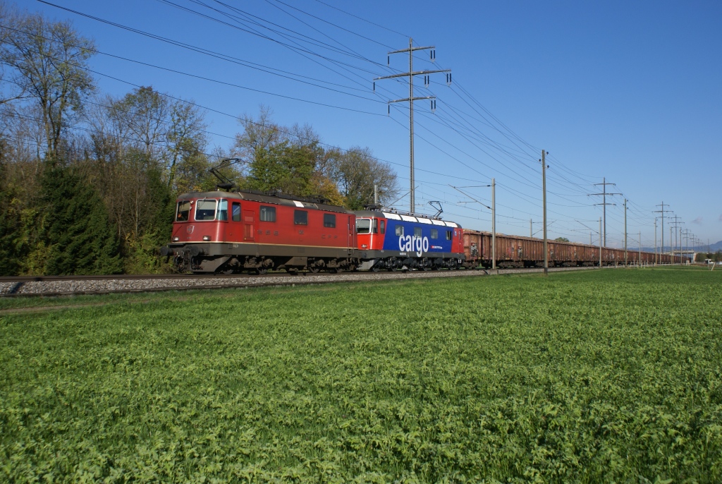 Re 4/4 II 11252 und Re 620 074-5 nhern sich am 21.10.10 Kiesen. Die Re 620 074-5 trgt wohl ihrem sauberen erscheinen und den glnzenden Drehgestellen zufolge noch nicht allzu lange den Cargo-Look.