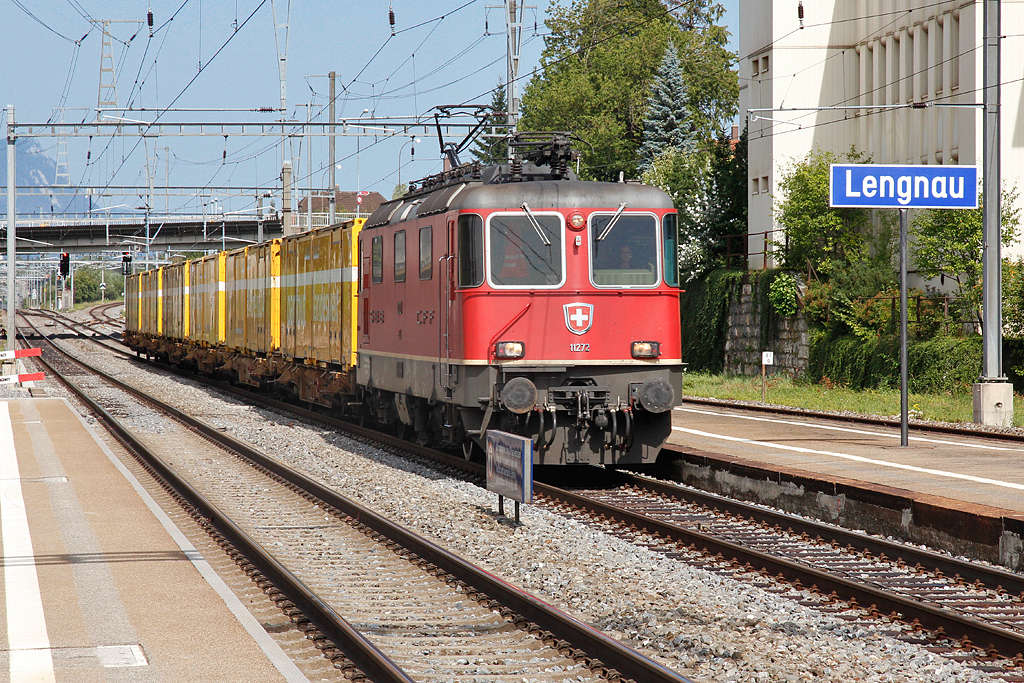 Re 4/4 II Nr. 11272 braust mit Postzug durch den Bahnhof Lengnau/BE in Richtung Biel/Bienne, 20. Aug. 2012, 15:50