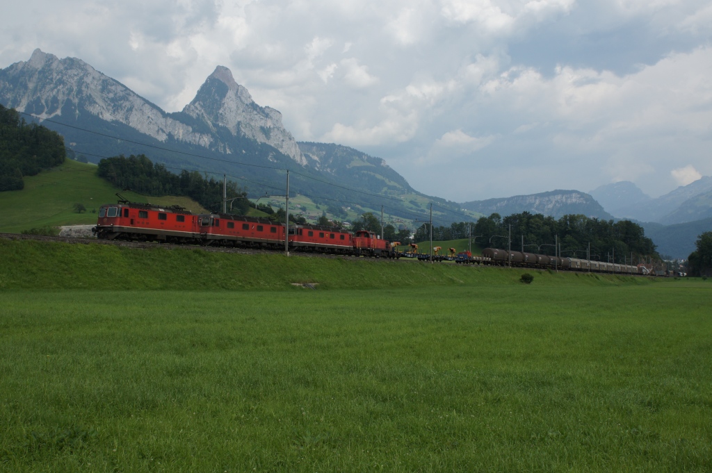 Re 4/4 III 11360, Re 6/6 11606, Re 6/6 11628 und eine unbekannte Am 841 fahren am 25.7.12 vor der Kulisse der Mythen von Schwyz Richtung Steinen.