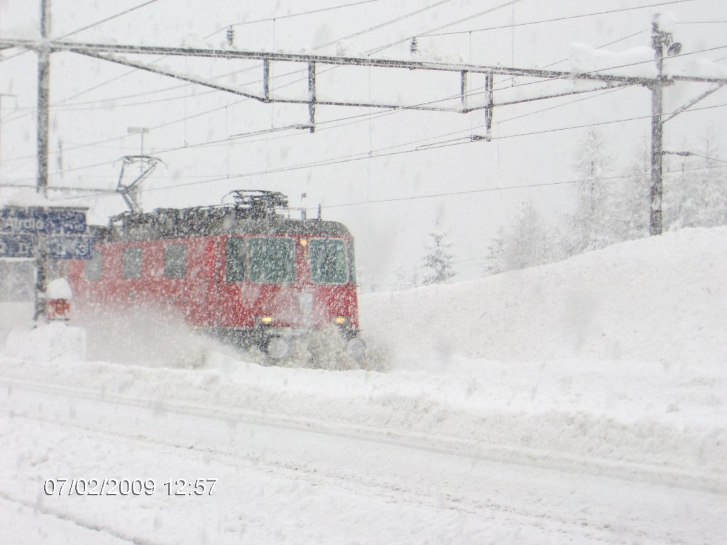 Re 4/4 mit IR 2178 bei Durchfahrt im tief verschneiten Bahnhof Airolo, 07.02.2010.