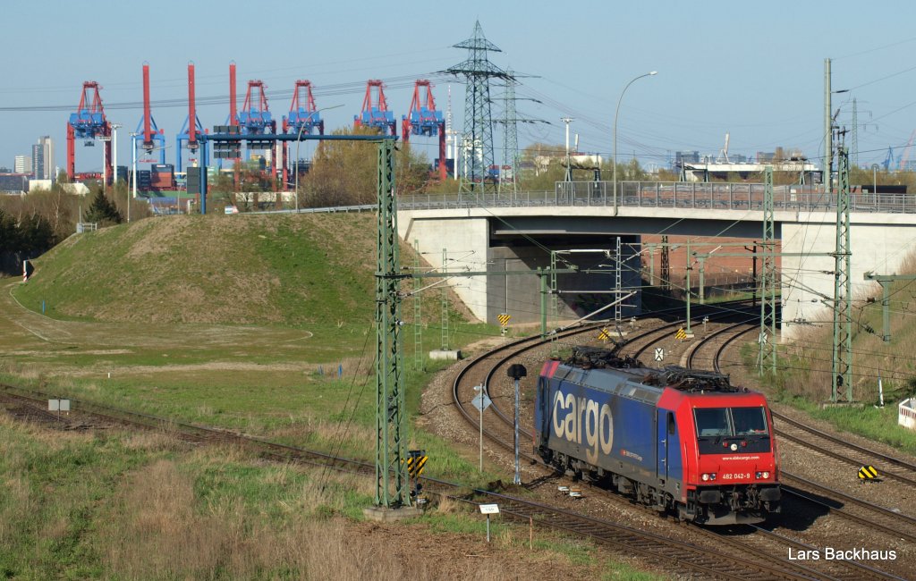 Re 482 042-9 rollt am 17.04.10 als Lz aus Hamburg-Waltershof in den Rbf Alte-Sderelbe. Im Hintergrund sind die groen Containerbrcken des Eurogate ud des Burchardkai zu sehen.