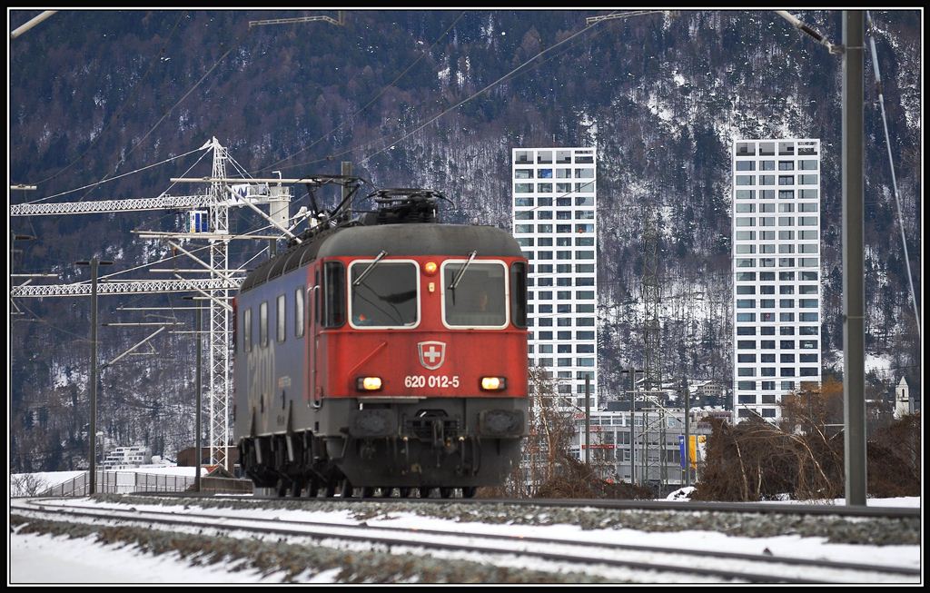 Re 620 012-5 ist auf dem Dreischienengleis unterwegs nach Ems Werk. Im Hintergrund die neue City West in Chur. (14.12.2012)