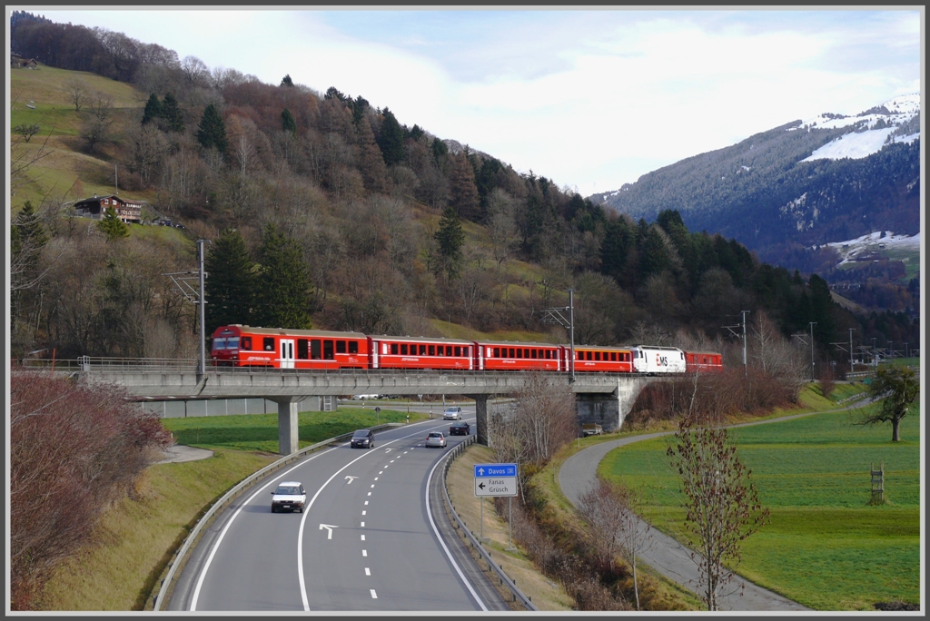 RE1036 aus Davos berquert die Prttigauer Strasse bei Grsch. An der Spitze befindet sich der Stadler Steuerwagen 1758 und die Ge 4/4 III 643  Vals  schiebt das Ganze. (20.11.2010)