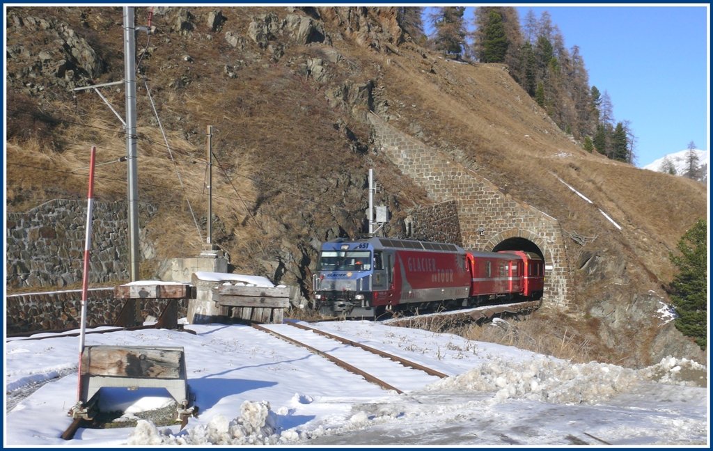 RE1141 aus Chur mit Ge 4/4 III 651  Fideris  verlsst soeben den 117m langen Argenteri Tunnel. Im Vordergrund enden drei Abstellgeleise des Bahnhofs St.Moritz in etwas komischer Anordnung. (11.11.2009)