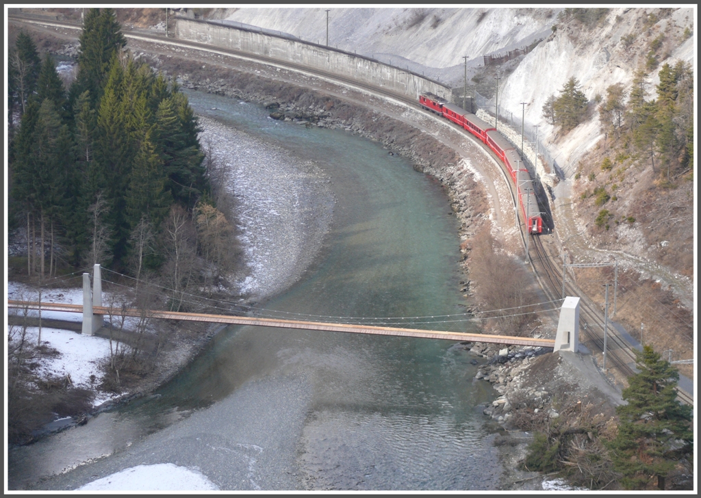 RE1232 verlsst den Bahnhof Trin und passiert die neue Hngebrcke fr die Fussgnger. (13.02.2011)