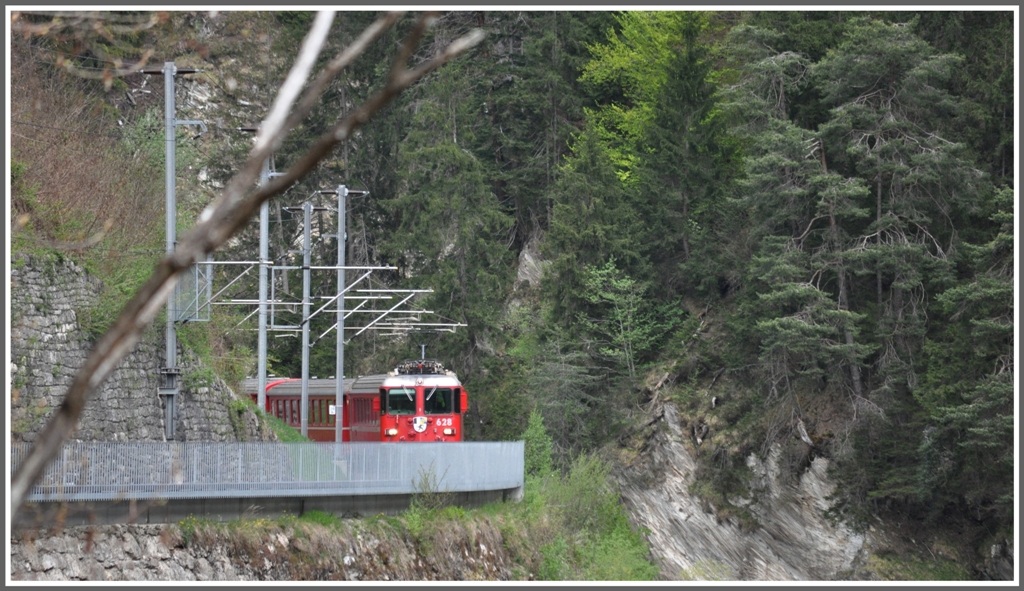 RE1240 mit Ge 4/4 628  s-chanf . Es ist eng hier in der Vorderrheinschlucht und Bahn mit Wanderweg folgen dem Fluss in erhhter Lage zwischen Reichenau und Trin. (29.04.2012)