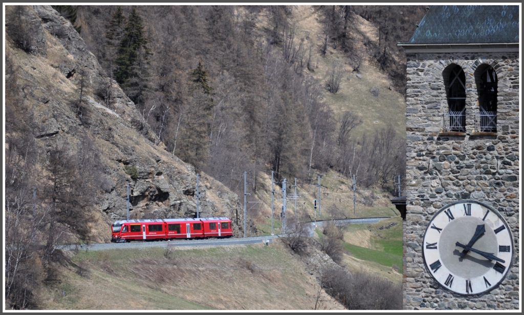 RE1342 auf dem Weg zum Vereinatunnel mit dem Kirchturm von Susch. (21.04.2012)