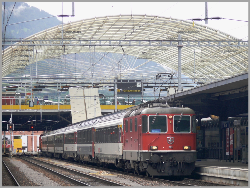 RE3836 mit Re 4/4 11122 nach St.Gallen steht abfahrbereit in Chur. Das Dach im Hintergrund berspannt die Postautostation. (18.06.2010)