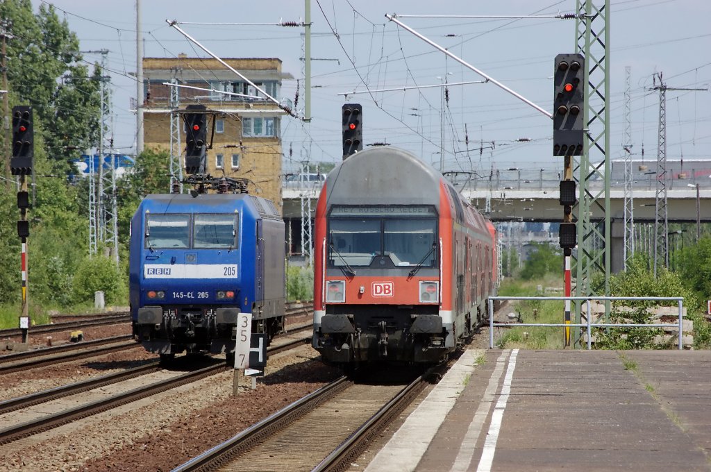 Rechts die RE7 (RE 38879) nach Rosslau (Elbe) bei der Ausfahrt aus dem Bahnhof Berlin Schnefeld gezogen von der 143 642-7. Links die 145-CL 205 (145 101-2) der RBH wartet auf die Ausfahrt aus dem Bahnhof Berlin Schnefeld. 29.06.2010