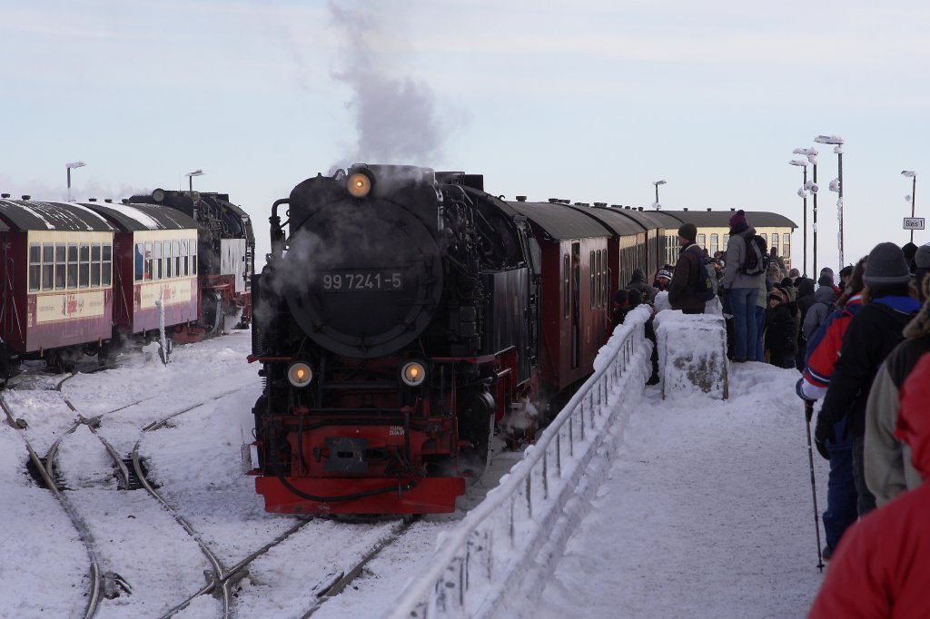 Reger Schmalspur-Bahnbetrieb in groer Hhe am 26.01.2013 im Bahnhof Brocken. Whrend auf Gleis 1 der soeben eingefahrene P8927 mit Lok 99 7241 aus Drei Annen Hohne, welcher nach dem Umsetzen der Lok als P8929 die Fahrt nach Nordhausen antritt, von den Fahrgsten  gestrmt  wird, wartet auf Gleis 3 der Sonderzug  Quedlinburger Brockenexpress  mit 99 7245 auf die Abfahrt nach Wernigerode.