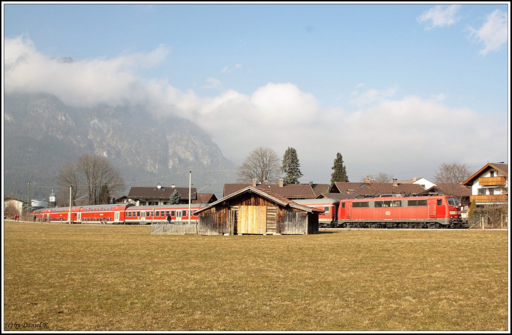 Regionalbahn von Mnchen Hbf hat gerade den Bahnhof Garmisch- Partenkirchen nach Mittenwald mit Zuglok 111. Im Vordergrund ein paar verlassene Huschen. (19.02.2011)