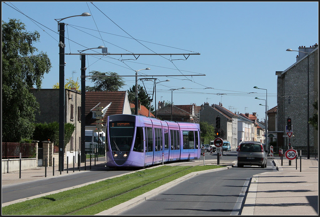 Reims, Rue Docteur Albert Schweizer - 

Die violette Bahn 103 biegt hier vom Boulevard de Belges in die Rue Docteur Albert Schweizer. Hier fährt die Straßenbahn auf der Fahrbahn, nur an den Enden ist jeweils ein kleines Stück auf der rechten Seite auf Rasenbahnkörper  um nicht im Autorückstau vor den Kreuzungen warten zu müssen. 

23.07.2012 (M)