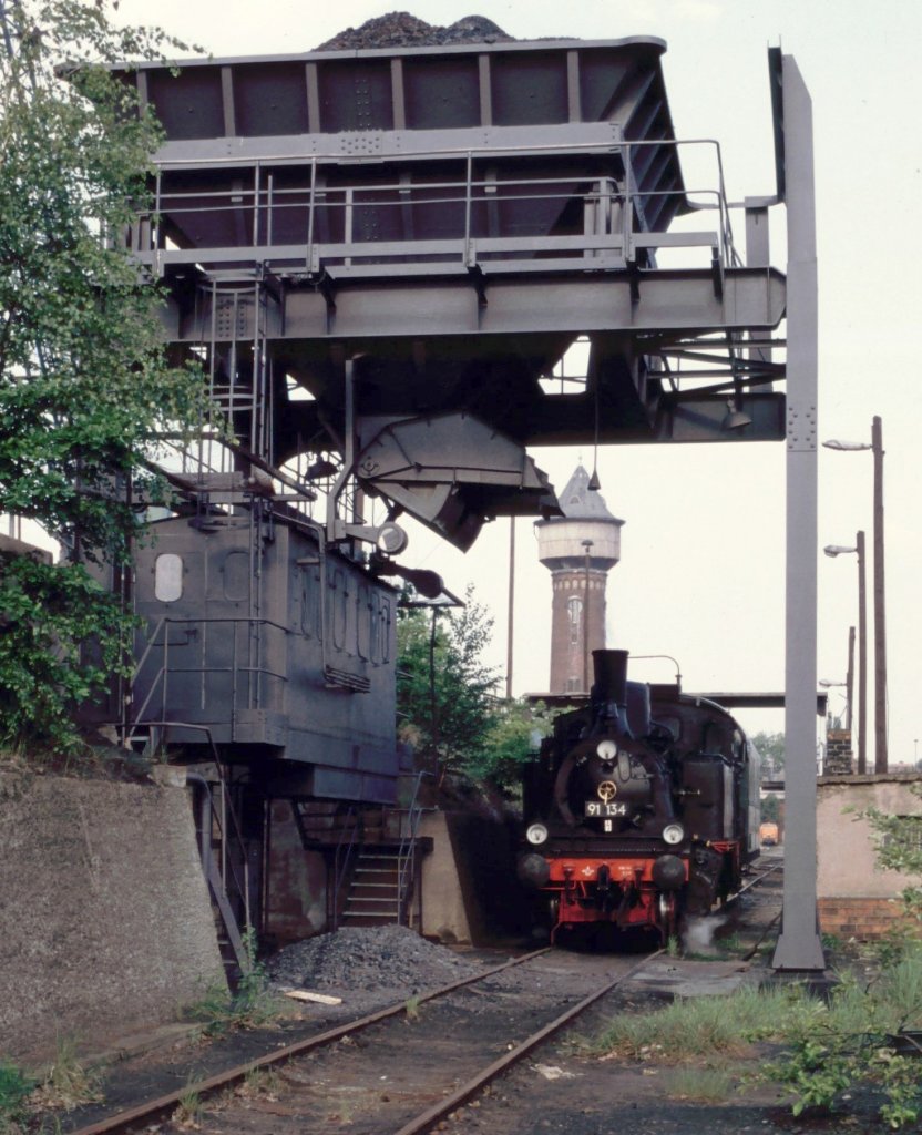 Restaurierter Hochbunker Bw Wustermark 1993 (man sieht die 91 134). Mit viel Mhe und erheblichem finanziellen Aufwand hatte man den Hochbunker in einen sehenswerten Zustand versetzt (damals gab es Bemhungen das Bw Wustermark zum Museums-Bw zu machen). Aber ... die Bahn schuf vollendete Tatsachen und kappte die Zufahrtsgleise. Alles umsonst - aber teuer. Im Hintergrund sieht man den weithin sichtbaren Wasserturm.