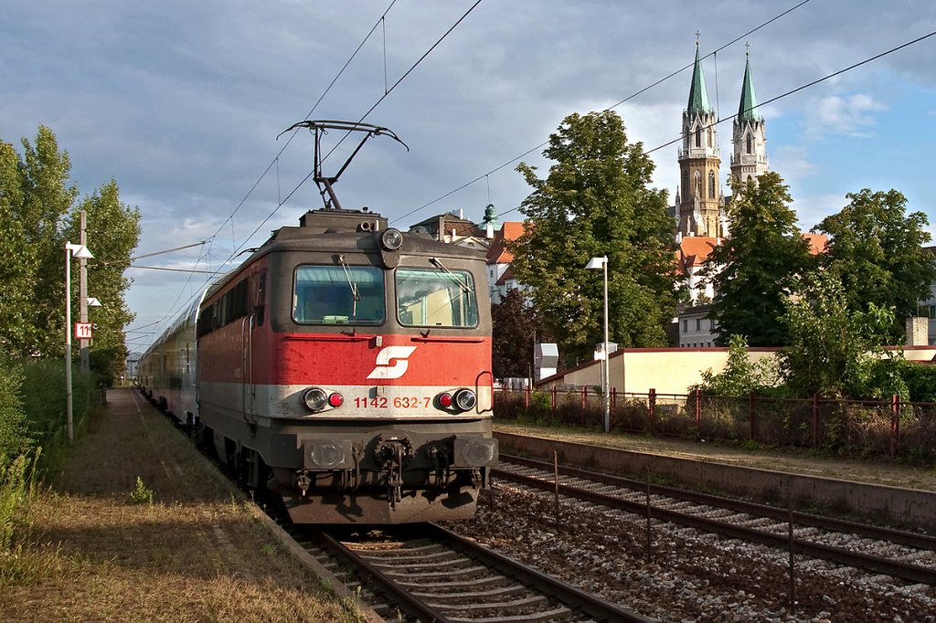 REX 7131 ist von Krems/Donau nach Wien FJB unterwegs. Die Aufnahme enstand am 22.07.2011 in Klosterneuburg-Kierling, rechts im HG sind die Kirchtrme von Stift Klosterneuburg zu erkennen.