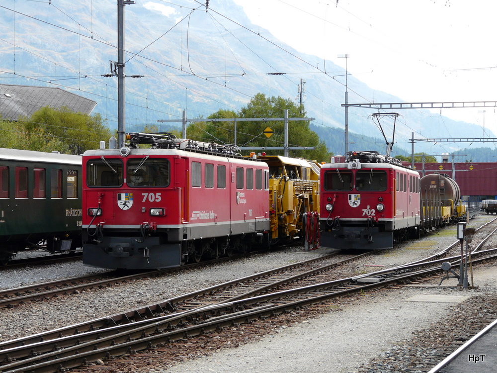 RhB - Gegenlichtaufname Loks Ge 6/6 705 und Ge 6/6 702 vor Gterzgen im Bahnhof Samedan am 16.09.2010