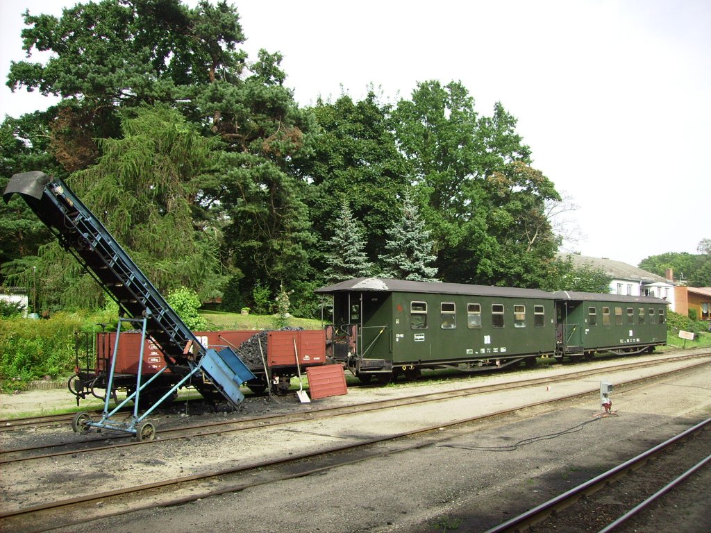 Richtiges DR-Feeling kommt am 25.08.2011 im Bahnhof von Ghren (Rgen) auf, als dort ein Niederbordwagen, ein Kohlefrderband und 2 Personenwagen auf einem Nebengleis abgestellt sind.