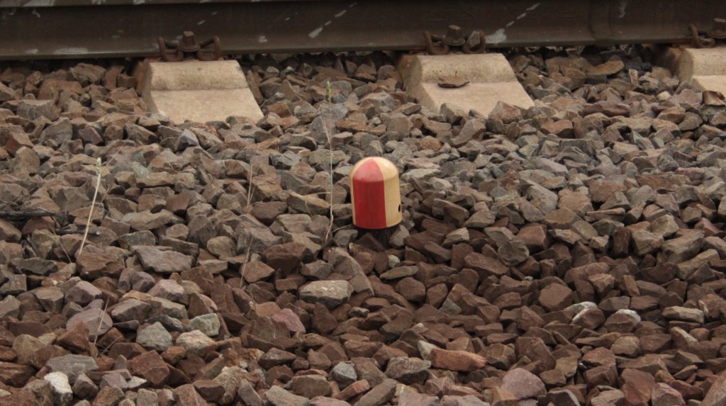 Rot-weises Teil, in Gleisbett an einer Weiche in Lehrte, wehr mei ums sich handelt. Foto vom 19.06.2011.