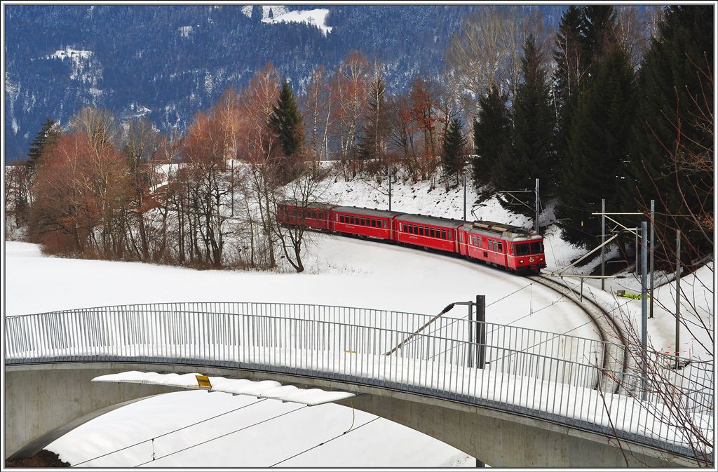 S2 1564 von Thusis nach Chur fhrt zwischen Bonaduz und Reichenau-Tamins talwrts. Die Fussgngerbrcke ersetzt seit kurzem einen unbewachten Bahnbergang. (15.02.2013)