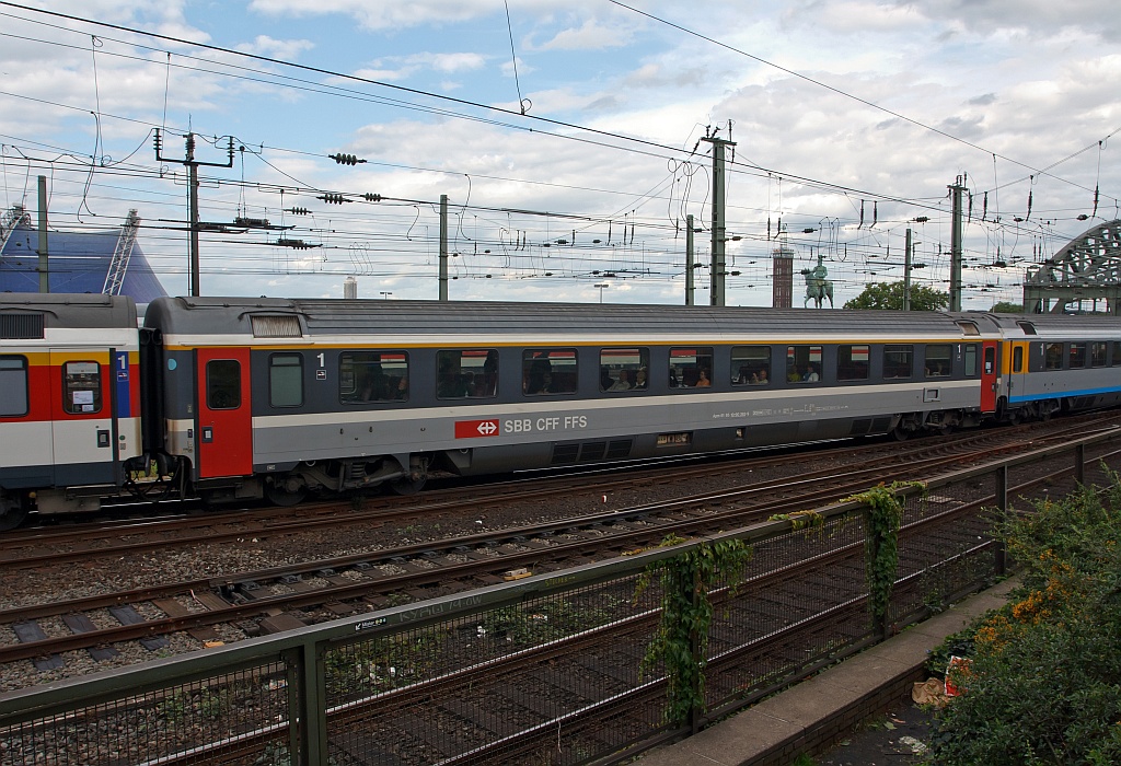SBB Apm 61, Schweizer Reisezuwagen (EC-Wagen, 1.Klasse), am 07.08.2011 an dem Verlassen des Klner Hupfbahnhofes, gleich geht es auf der Hohenzollernbrcke ber den Rhein. 
