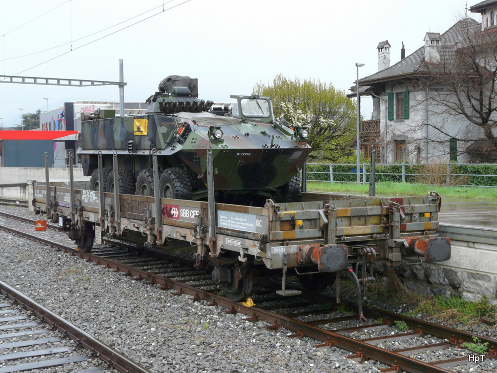 SBB - Gterwagen Ks 21 85 337 1 004-0 beldaen mit Militrfahrzeug im Bahnhof von Aigle am 09.04.2012