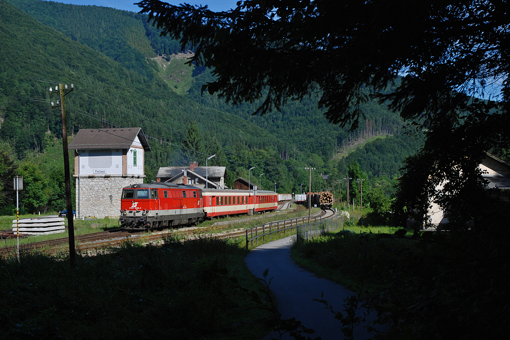 Schattenspiele mit einem Hauch von Vergangenheit: 2143 038 mit R 6790 bei der Ausfahrt aus dem Bahnhof Freiland Richtung St. Aegyd am Neuwalde, 02.08.2010.