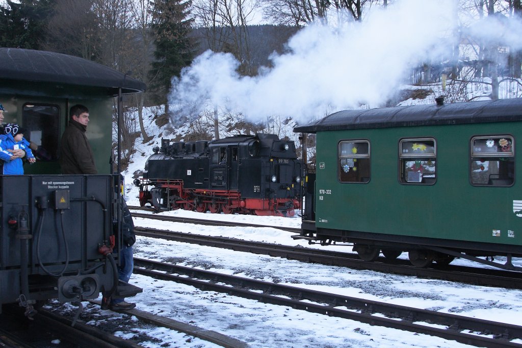 Schnappschu  durch die Lcke  am 30.12.2012 im Bahnhof Oberwiesenthal, aufgenommen vom Bahnsteig aus. Das Bild zeigt 99 785 beim Rangieren. Links im Bild steht P1008, welcher in Krze unter Traktion von 99 786 nach Cranzahl fahren wird. Diese Maschine befindet sich zum Aufnahmezeitpunkt noch zum Wasserfassen im Bw.